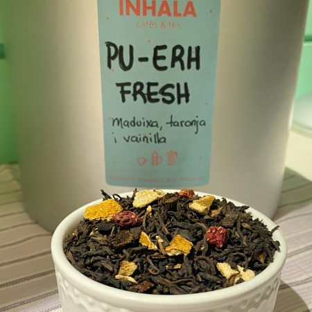 El te Pu-erh Fresh està aromatitzat amb pell de taronja, trossets de maduixa deshitradata i vainilla natural. Es un te provinent de Yunnan, China. Dóna una tassa suau, afruïtada, amb un punt dolç que el fa molt agradable per prendre a qualsevol hora del dia. El Pu-erh té propietats depuratives, és antioxidant i ric en vitamines. El temps de infusió recomanat és de 4 minuts i la temperatura recomanada de l' aigua és de 90ºC màxim. A INHALA t’oferim la següent selecció del meravellós te Pu-erh: . Pu-Erh Fruites del Bosc i Figues . Pu-Erh Sorbet de Llima . Pu-Erh Cranberry . Pu-Erh a la Vainilla Bourbon . Pu-Erh Chai . Pu-Erh Imperial natural Vols saber una mica més sobre la nostra selecció de tes i infusions? Quan arriba la calor de l' estiu, aquest te també és ideal per prendre “en fred”. A INHALA Cafès i Tes t’oferim una exclusiva selecció de tes verds, tes blancs, tes negres, tes Pu-erh, tes Oolong, també tes desteïnats, Rooibos, tisanes (herbal teas) i infusions de fruites (fruit teas). T’esperem a Portalet, 9 de Granollers, Barcelona amb la millor selecció de cafès, tes, infusions, galetes, xocolates i molts complements per la taula i cuina.