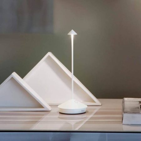 La làmpada de sobretaula Pina Pro de Zafferano en color sand és un detall ben bonic per la taula mentres et prens un cafè o un te tranquil.

És una làmpada amb bateria, portàtil i recargable.

A la base té el control tàctil per l'encesa, per regular la intensitat lluminosa i la selecció de la temperatura del color de la llum.

Aquesta làmpada també és ideal per exterior gràcies a la seva protecció.

Disposa d'un sistema de control electrònic que supervisa i mostra l'autonomia de la bateria permetent així optimizar i aseegurar sempre la recàrrega correcta.

S'inclou l'endoll de càrrega pel model LD1650 i NO inclòs pel LD2650.

Té 3 anys de garantia.



A INHALA ens agrada cuidar els detalls per la teva taula però els protagonistes sempre són els cafès en gra que podrem moldre al moment i les seves aromes et seduïràn a l’instant a més d'una acurada selecció de tes i infusions, delicioses galetes i xocolates.