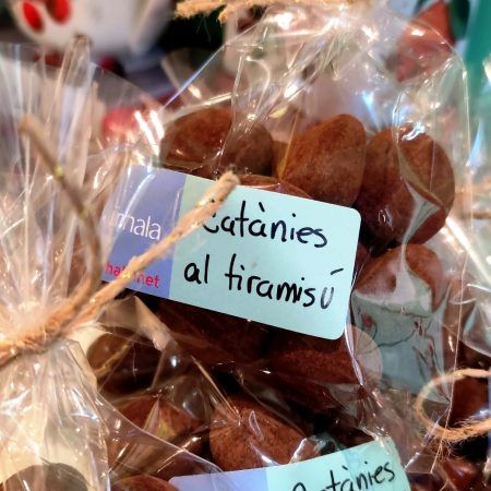 Las Catanias al Tiramisú son bombones de chocolate elaborados con almendras enteras de la variedad “marcona” caramelizadas y recubiertas con praliné de chocolate blanco, almendra, avellana y azúcar. Finalmente, se espolvorean con cacao en polvo. Son deliciosas y perfectas en un momento de café y té, también son ideales para acompañar una copa de cava o un gintonic en buena compañía. NO contienen gluten. Las servimos en bositas de celofan con 100 gramos de peso neto. En INHALA Cafés y Tés te ofrecemos las catanias a granel y podrás elegir los siguientes sabores: Catanias «receta original» al Cacao, las Catanias Green Lemon, las Dark con chocolate negro y las que llevan Frambuesa, sencillamente deliciosas.